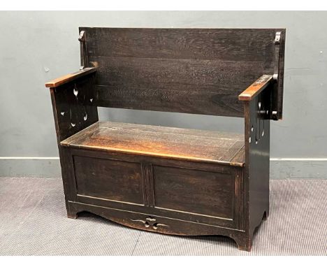 An Arts and Crafts style "monk's bench" with lift up seat for storage, and metamorphic back. 83cm H x 122cm W x 48cm D