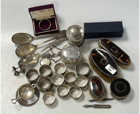 A collection of silverware including napkin rings, tea strainer, dressing table items, tea caddy, flatware etc., 792.7g (25.5