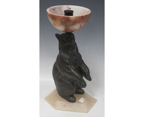 Two Art Deco lamp bases, the first bronzed spelter in the shape of a bear 33cm high, the other onyx with dolphins at the base