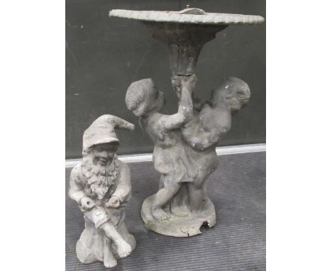 A lead bird bath supported by a pair of cherubs, 60cm high; together with a smaller lead model of a gnome, 40cm high