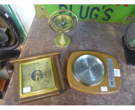 A table top brass compass and two barometers