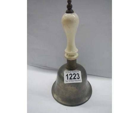 An hold hand bell with ceramic handle. 