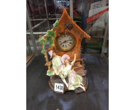 A bisque mantel clock depicting Courting Couple on bench with clock housed in a roofed folly 