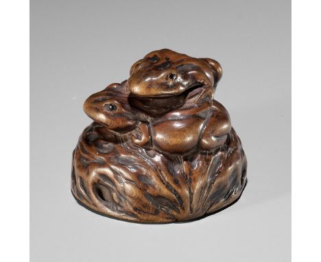 ISSAN: A WOOD NETSUKE OF TWO TOADS ON A WALNUTBy Ryusansai Issan, signed Issan 一山 with a kakihanJapan, Iwashiro Province, c. 