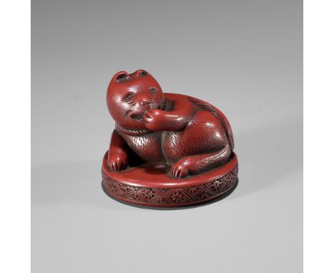 A RARE TSUISHU LACQUER NETSUKE OF A CATUnsignedJapan, 19th century, Edo period (1615-1868)Finely carved and lacquered in tsui