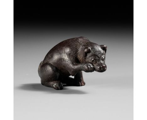 A RARE DARK WOOD NETSUKE OF A DOG SCRATCHING ITS JOWLUnsigned Japan, probably Nagoya, 18th century, Edo period (1615-1868)Fin