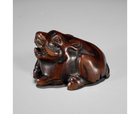 A FINE TANBA SCHOOL WOOD NETSUKE OF A RECUMBENT BOARUnsignedJapan, Tanba province, late 18th to early 19th century, Edo perio