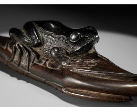 KANMAN: AN EXCEPTIONAL AND LARGE KUROGAKI (BLACK PERSIMMON) WOOD NETSUKE OF A FROG ON A LOTUS LEAFBy Kanman (1793-1859), sign