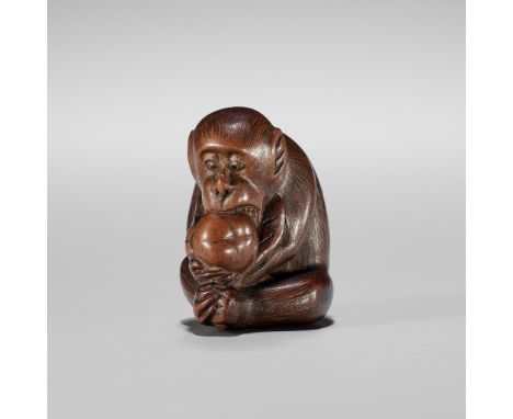 A WOOD NETSUKE OF A MONKEY EATING A PERSIMMON (KAKI)Unsigned Japan, probably Gifu, late 19th centuryThe darkly stained wood f