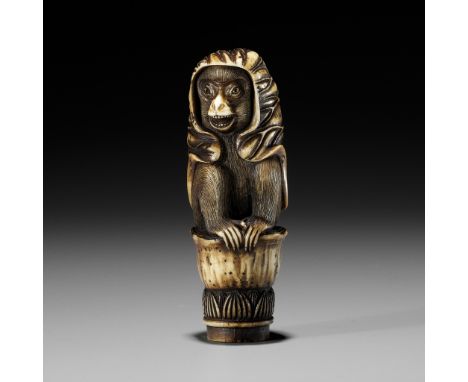 KOKU: A STAG ANTLER KNIFE HANDLE IN THE FORM OF A MONKEY WITH A LOTUS CLOAKBy a follower of Ozaki Kokusai (1853-1892), sealed