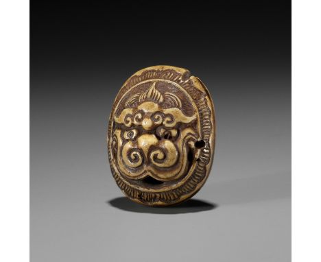 KOKUSAI: A STAG ANTLER RYUSA MANJU NETSUKE DEPICTING A ROOF TILE WITH ONI MASK (ONIGAWARA)By Ozaki Kokusai (1835-1892), seale