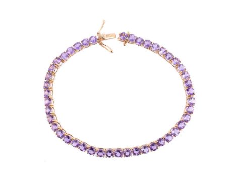 
	
		AN AMETHYST TENNIS LINE BRACELET
		The circular cut amethysts within four claw settings, to a concealed box clasp, the t