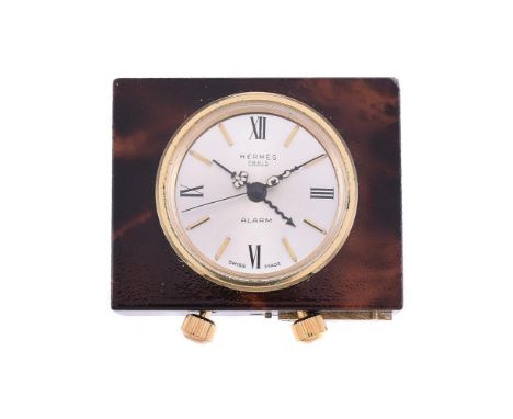 
	
		HERMES
		A BRASS AND BROWN LACQUERED TRAVEL ALARM CLOCK
		Movement: Manual wind
		Case: Brown lacquered brass
		Dial: Si