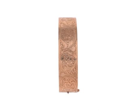 
	
		A 9 CARAT GOLD HINGED BANGLE 
		LONDON 1958
		The broad bangle etched with acanthus leaf scrolls with flower heads betwe