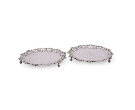 A PAIR OF SILVER SHAPED CIRCULAR WAITERS FRANK HAWKER LTD., BIRMINGHAM 1972 With a shell and scroll border, on three foliate 