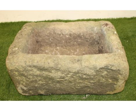 A SMALL SANDSTONE TROUGH of rough hewn regular oblong form, 21" x 14"