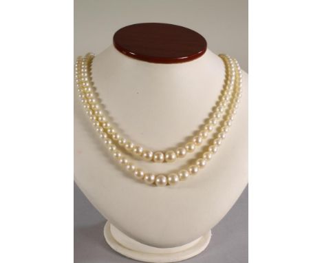 A DOUBLE STRAND CULTURED PEARL NECKLACE, the graduated pearls strung to a 9ct gold flowerhead clasp further set with similar 