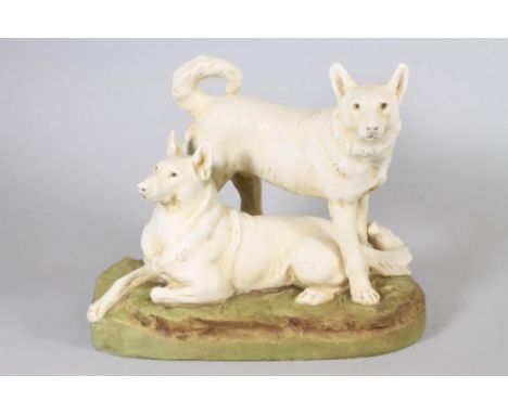 A ROYAL DUX PORCELAIN DOG GROUP modelled as two Japanese Hokkaido recumbent and standing, on a naturalistically moulded round