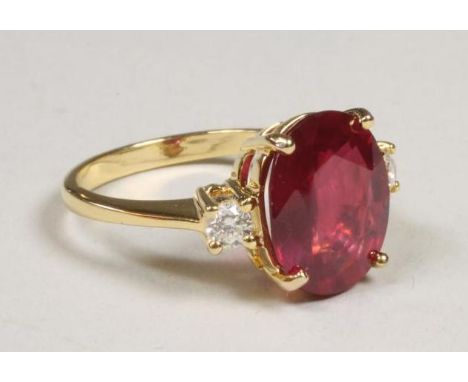 A RUBY DRESS RING, the oval facet cut ruby of approximately 5cts, claw set to diamond shoulders and a plain 14kt gold shank, 