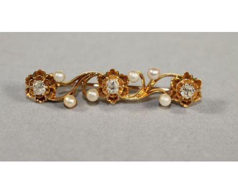 A DIAMOND AND PEARL BROOCH of oblong scroll form claw set with three old cut diamonds and six pearls, unmarked