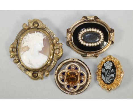 TWO VICTORIAN MOURNING BROOCHES, both oval, one with a black and white flower carved hardstone in a stamped hollow mount, the