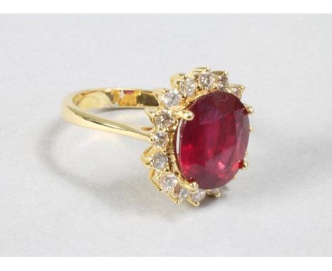 A RUBY AND DIAMOND RING to match the previous lot, the ruby of approximately 6.10cts claw set to a border of sixteen small br