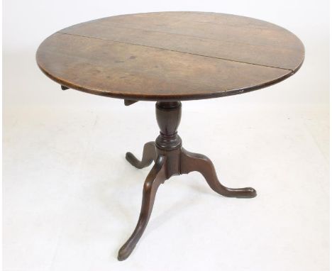 A GEORGIAN OAK TRIPOD TABLE, c.1770, the tip up circular plank top on turned vase stem, raised on cabriole legs and pad feet,