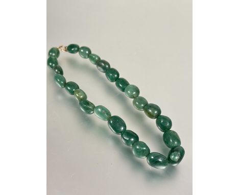 A 1920s celadon green Jadeite mottled pebble necklace with yellow metal ring fastening L x 19.5cm&nbsp;