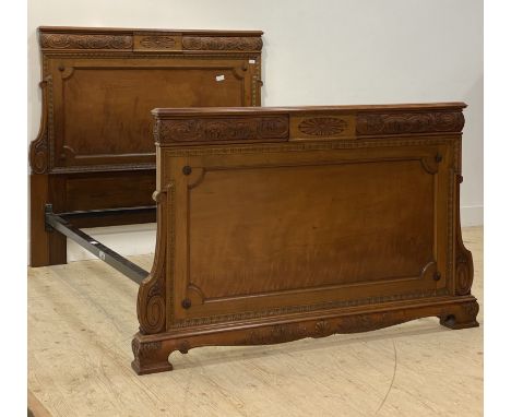 An Edwardian walnut panel end double bed frame, the head and foot well carved with paterae, acanthus, running waterleaf and s