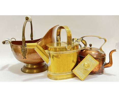 A group of copper and brassware comprising a ceramic handled copper coal scuttle (h- 34cm, w- 36cm), a brass watering can, a 