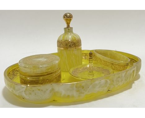 A gilt yellow glass dressing table set with raised scrolling foliate decoration to rim, comprising a quatrefoil tray (w- 28.5