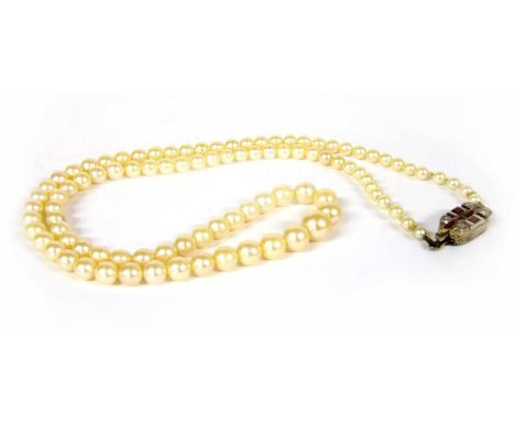 A single row graduated cultured pearl necklace, with a synthetic ruby and diamond clasp