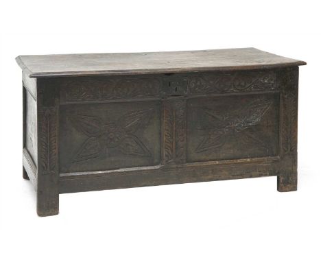 A 17th century oak coffer, the plank top over a later carved two-panel front, 122cm wide, 62cm high