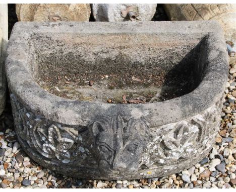 A composite stone trough, 20th century, with relief foliate decoration, set with a lion mask, 63cm wide 56cm deep 28cm high