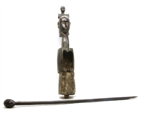 A Zambian (?) carved wood musical instrument, with double head, 70cm long, and a hardwood head stick, 87cm long (2)