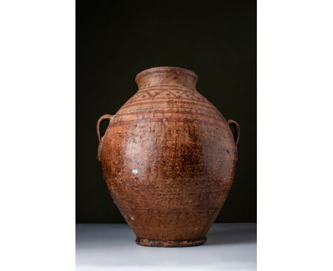 Ca. 300 - 100 BC. A terracotta amphora with a large ovoid body that gently tapers towards a thick ring base. The short neck t