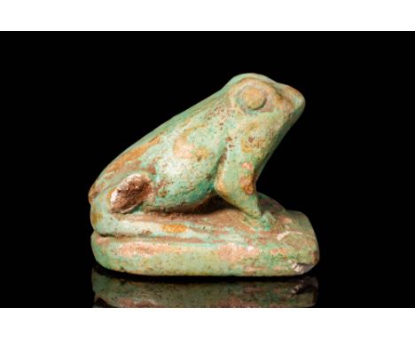 New Kingdom, Ca. 1500 - 1069 BC. A green faience frog resting on an integral base. The head is raised, with prominent, rounde