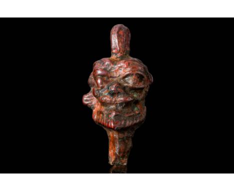 Ca. 800 - 600 BC. A bronze amulet in the form of the head of the demon god Pazuzu, depicted with exaggerated facial features 