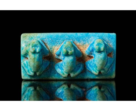 Late Period - Ptolemaic Period, Ca. 664 - 30 BC. A rectangular amulet of blue faience with three moulded frogs in squatting p