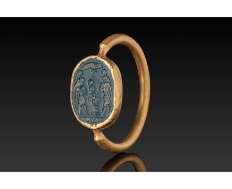 Ca. 600 - 300 BC. A green chalcedony intaglio engraved with a triad of Egyptian deities standing frontally, each surmounted b