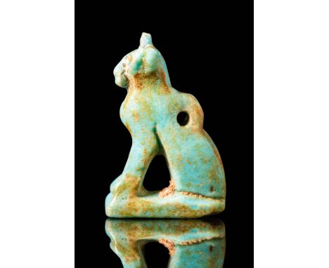 Late Period - Ptolemaic Period, Ca. 664 - 30 BC. A pale blue faience amulet in the form of a seated cat with its forelegs ext