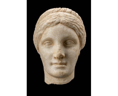 Ca. AD 100 - 200.A marble head of a noblewoman, inspired by a Greek bronze statue, with idealised facial features. The smooth