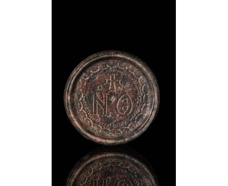 Ca. AD 400 - 600. A bronze weight of discoid form with raised rim and recessed central field. The upper surface is engraved w