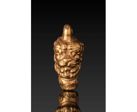 Ca. 800 - 600 BC. A gold amulet in the form of the head of the demon god Pazuzu, depicted with exaggerated facial features an