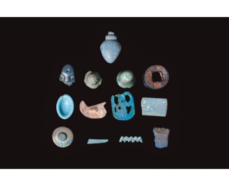 Ca. 1550 - 332 BC. A group of 13 faience objects, including a Heh amulet representing the personification of eternity, shown 