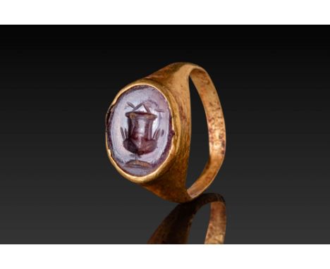 Ca. AD 1 - 100. An oval red intaglio engraved with a wine krater. The intaglio is mounted in a plain collet bezel, and the ho