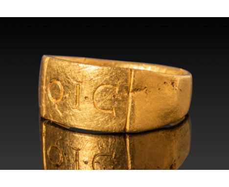 Ca. AD 1 - 100. A gold ring with a flat, broad hoop featuring three engraved Roman capital letters Q·I·C· separated by interp