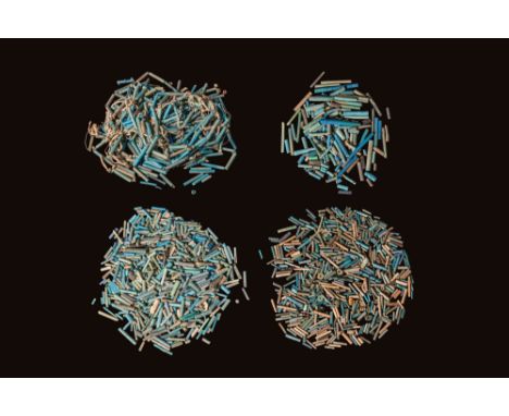 Ca. 1550 - 332 BC. A large collection of faience beads in shades of turquoise, blue, and green, comprising primarily tubular 