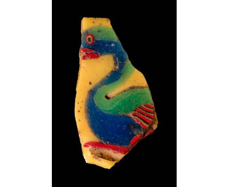 Ca. 30 BC - AD 200. A polychrome glass inlay fragment depicting a stylised swan in profile, against a yellow ground. The body