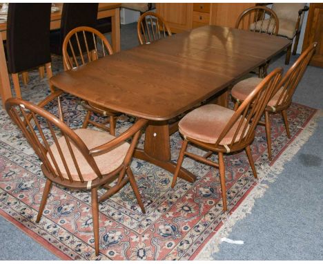 An Ercol Elm extending dining table, 202cm by 91cm by 73cm, together with a set of six matching stick back Windsor dining cha